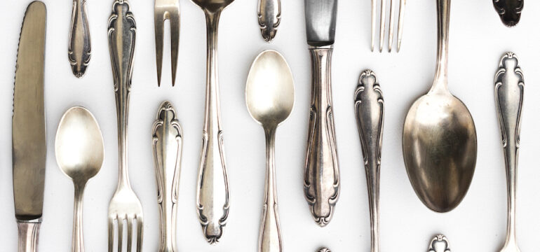 Beautiful sterling silver cutlery collection on a white background.