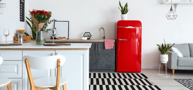 Interior of modern kitchen painted appliances counters and painted red fridge.