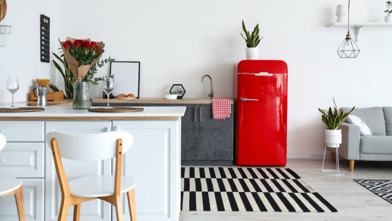 Interior of modern kitchen painted appliances counters and painted red fridge.