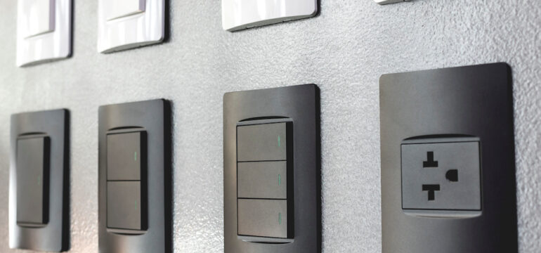 Various electrical outlets and light switches are on display at a hardware store.