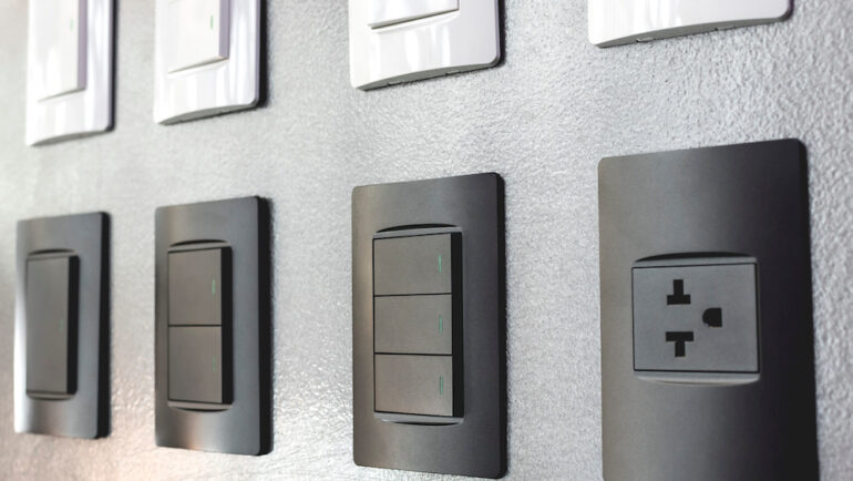 Various electrical outlets and light switches are on display at a hardware store.