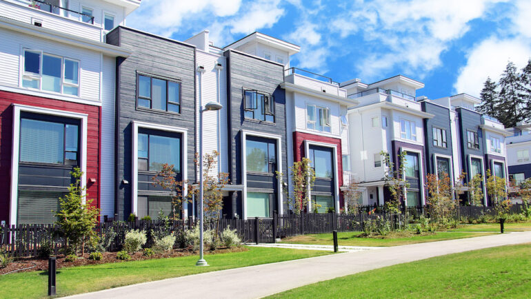 Beautiful new construction attached townhomes with colorful summer gardens. Example of new home builder communities.