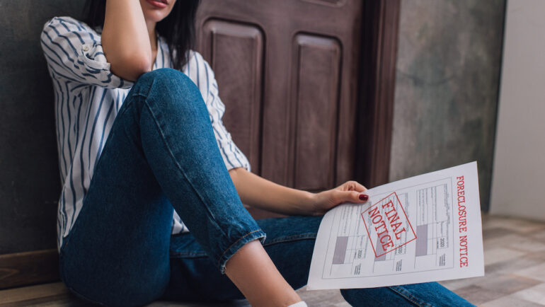 Cropped view of woman holding document with foreclosure and final notice from a zombie mortgage.