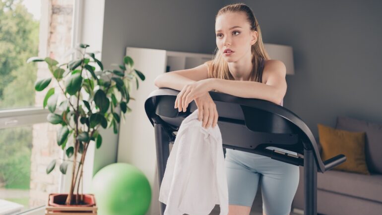 Photo of girl training at home on gym equipment she has buyers remorse after buying.