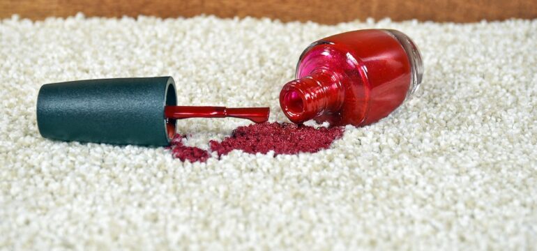 Red nail polish spill on light colored carpet.