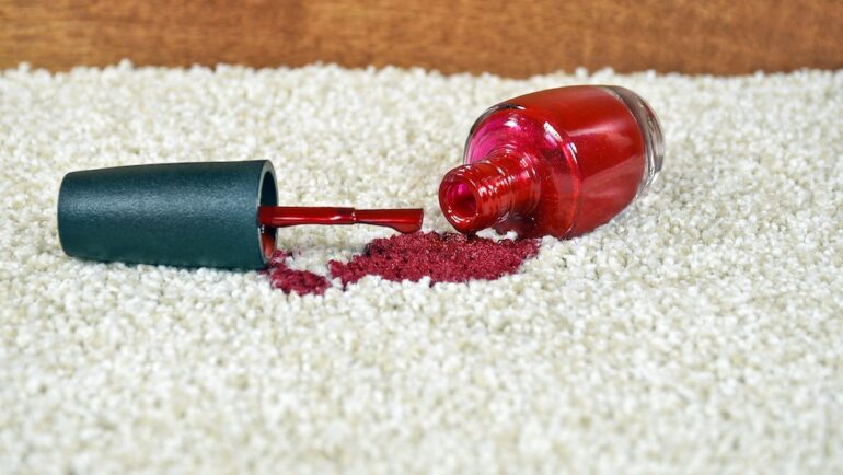 Red nail polish spill on light colored carpet.