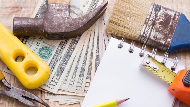 Concept of contractor theft with tools and cash on a work bench.