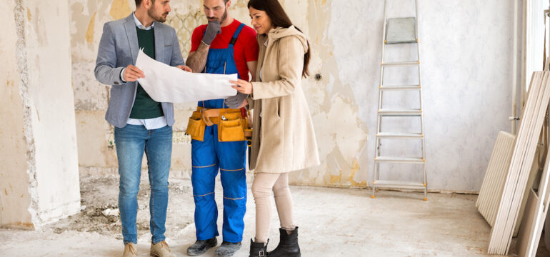 A young couple shows a home builder a problem with the construction of their new home.