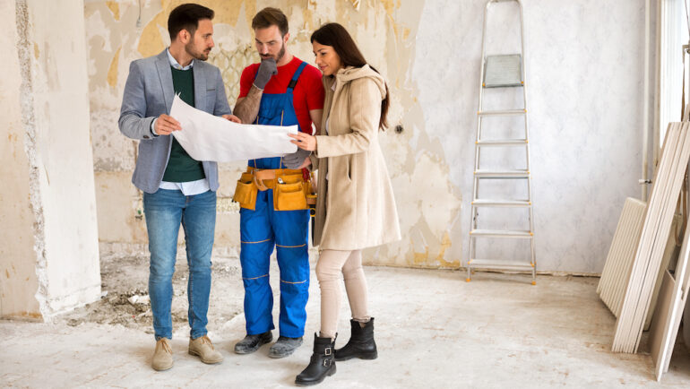A young couple shows a home builder a problem with the construction of their new home.