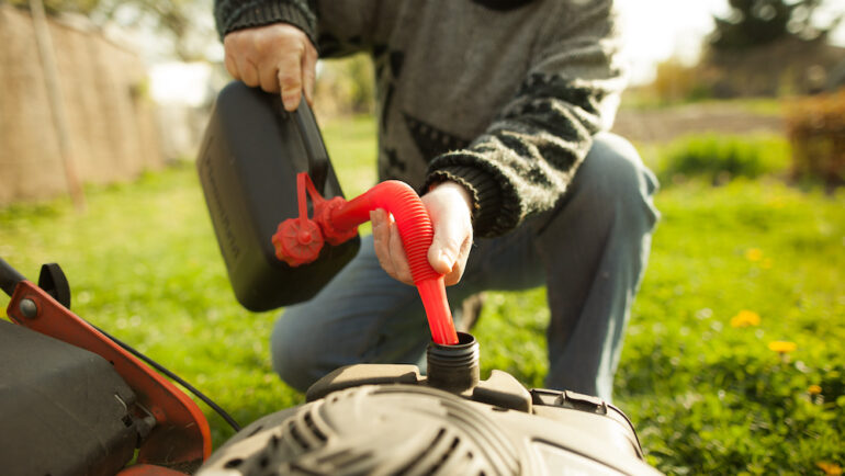 Gentleman adding fuel stabilizer to his lawn mower engine.