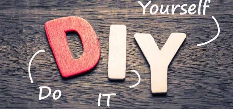 Wood letters of DIY acronym and definition on wood background.